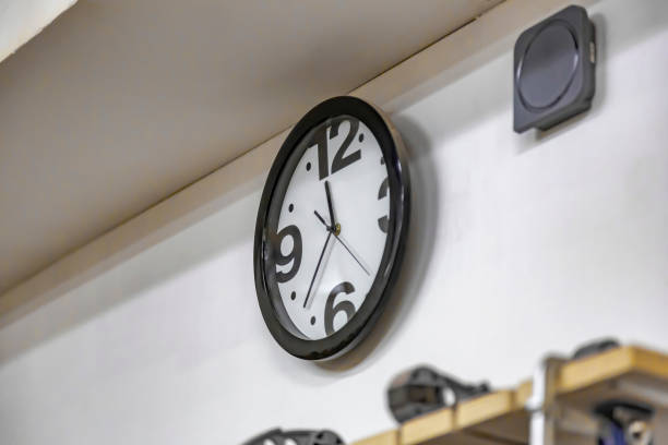 istock Minimalistic design of a clock on a dirty light wall 1321506677