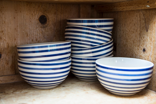 Seven bowls on rustic wooden shelves