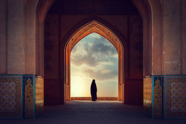 伝統的なイラン建築を背景に国民的な服装をしたペルシャ人女性のシルエット。日没。イラン。カシャン。 - mosque ストックフォトと画像