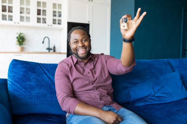 istock Happy African guy looks at the camera and shows keys 1321510107