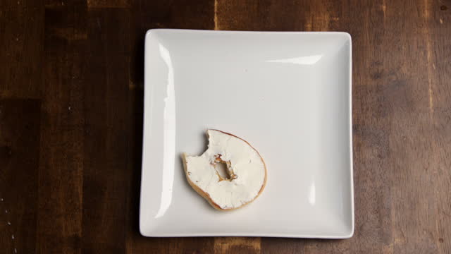 A Stop Motion video of a  Bagel being covered in cream cheese and then eaten