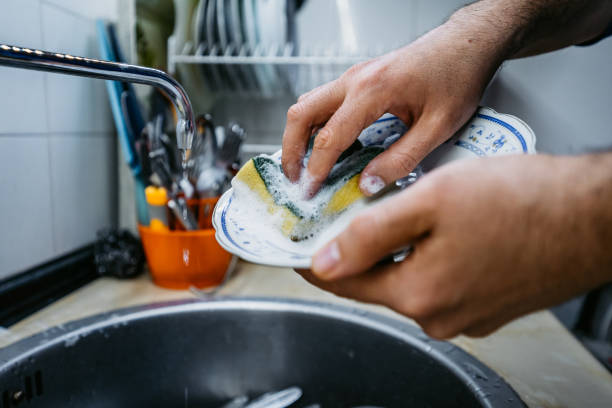istock Man washing dishes at home 1321519865