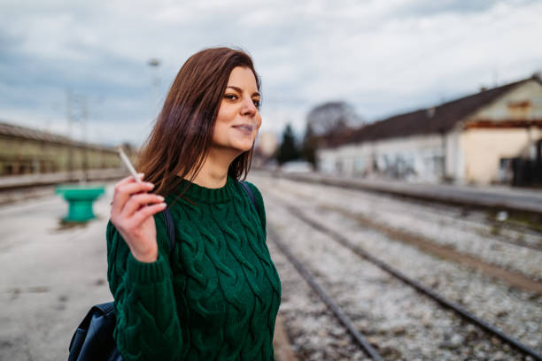 frau raucht während wartenden zug - leaving loneliness women railroad track stock-fotos und bilder