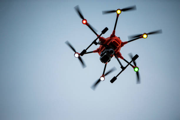 istock Orange hexacopter drone hovering in dusk sky viewed from below 1321521450