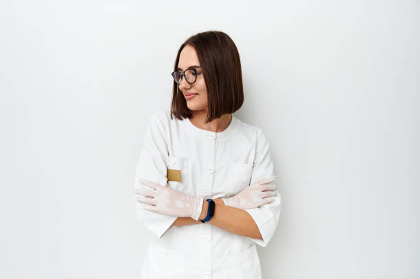 Beautiful doctor looking away while posing on camera over white background with copy space Beautiful female doctor looking away while posing on camera over white background with copy space aesthetician photos stock pictures, royalty-free photos & images