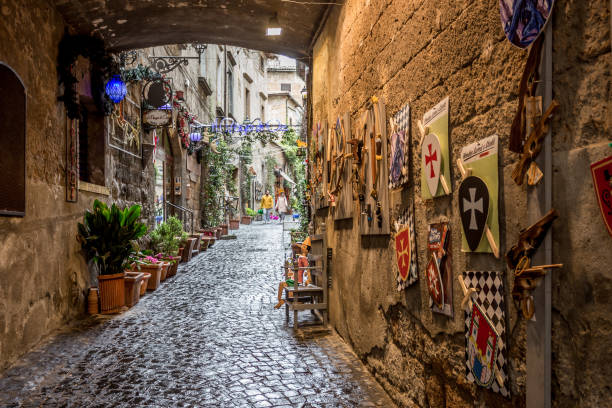 Beautiful view of narrow street with small Shops, frisky alley near the Cathedral of Orvieto, Umbria, Italy Orvieto, Italy, April 2019: Beautiful view of narrow street with small Shops, frisky alley near the Cathedral of Orvieto, Duomo di Orvieto, Umbria, Italy orvieto stock pictures, royalty-free photos & images