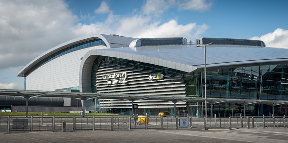 Panoramic of the exterior sign on side of the building at Terminal 2 at Dublin Airport, Ireland, on a sunny day with broken clouds