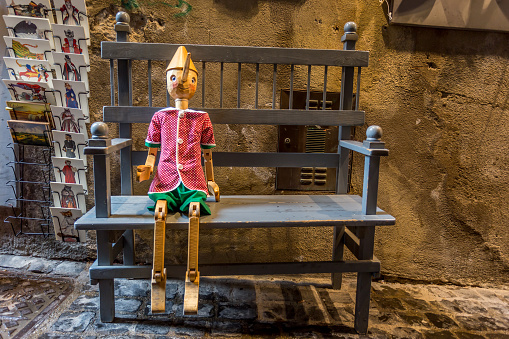 Orvieto, Italy, April 2019: Wooden statue of Pinocchio with donkey ears and long nose. Pinocchio is the protagonist of a famous Italian fairy tale