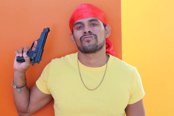 Angry looking man holding a gun.