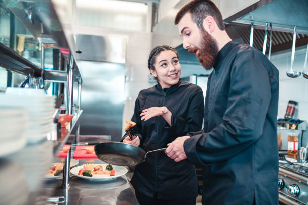 istock Modern Chef Checking Female Students Cooking Skills In Kitchen 1321531929