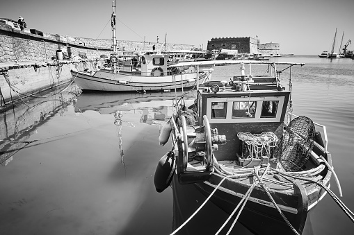 Fishing boats in Venetian Harbor of Heraklion, Crete Island, Greece. Black and white photography