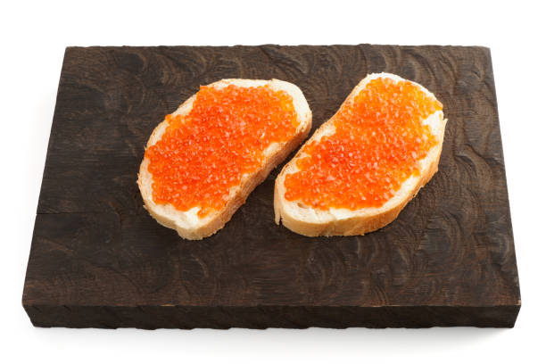 sanduíches de rosto aberto com ovas de salmão em tábua de madeira - plank bread caviar close up - fotografias e filmes do acervo