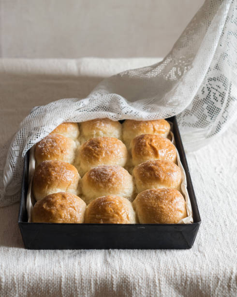 istock Homemade bread rolls in baking tin mold on linen tablecloth. Selective focus 1321537500