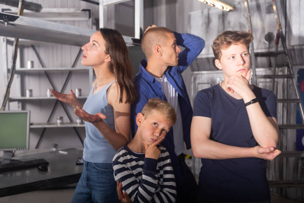 istock Interested family contemplating solving conundrums in escape room 1321539930