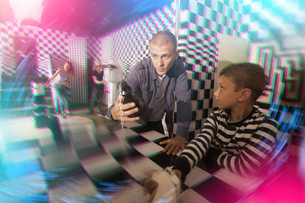istock Man with preteen son solving puzzle in chess quest room 1321539958