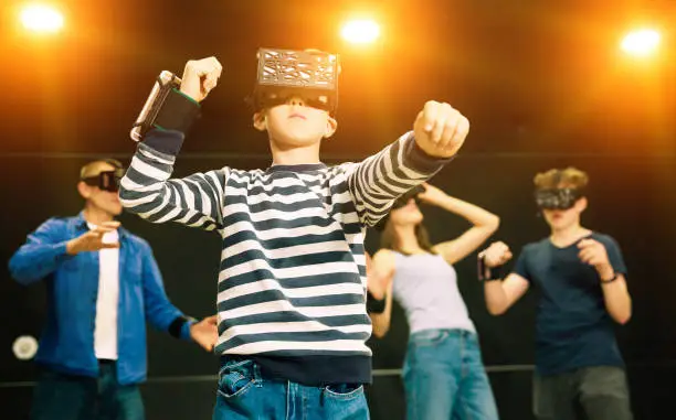 Photo of Tween boy in vr headset playing game with family