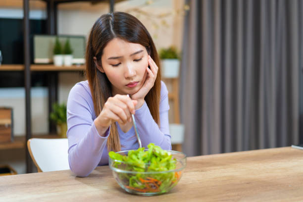 asian woman bored to eat vegetable salad want to quit vegetarian - anorexia imagens e fotografias de stock