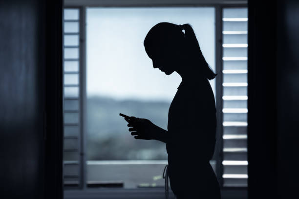 istock Young woman using smartphone a dark gloomy setting. 1321546778