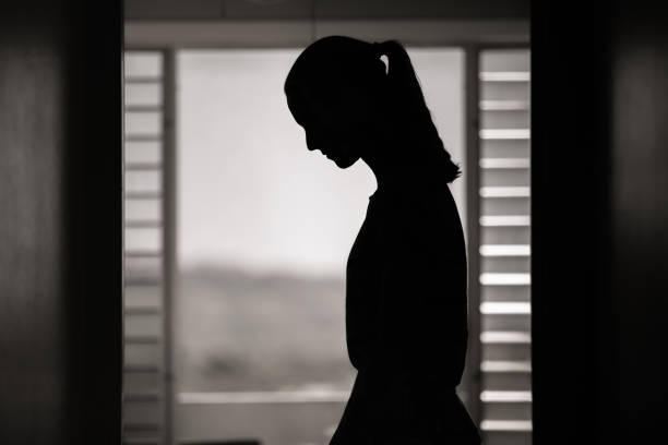istock Young female indoors looking down feeling sad and depressed 1321547529