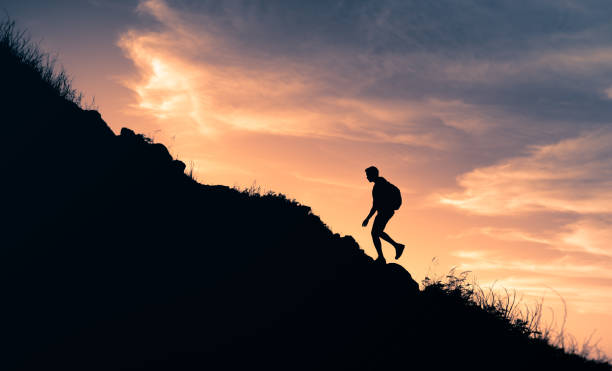 istock Man hiking to the mountain top at sunset. 1321548401