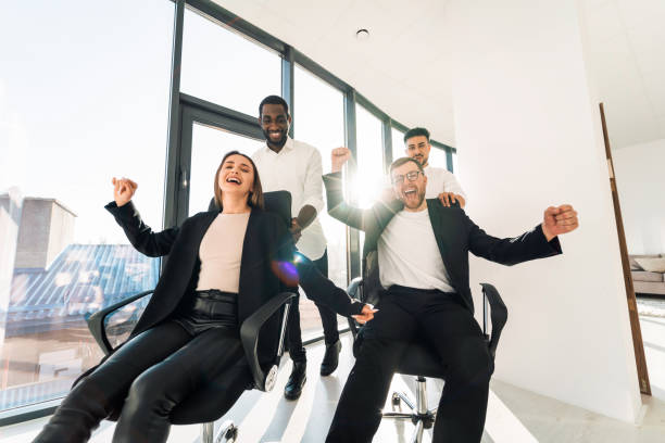istock Young business people ride chairs in the office 1321548412