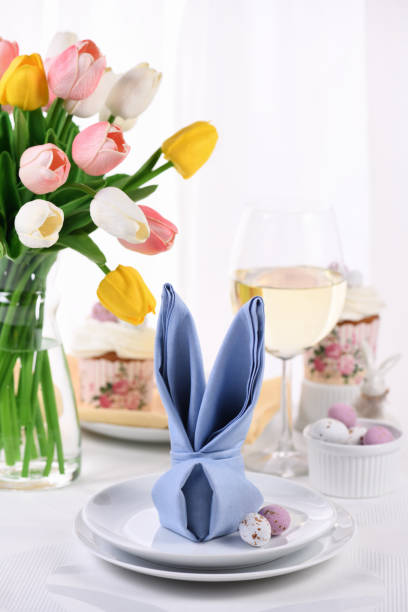 A napkin folded in the shape of a hare (rabbit), the concept of setting a festive table in honor of Easter. stock photo