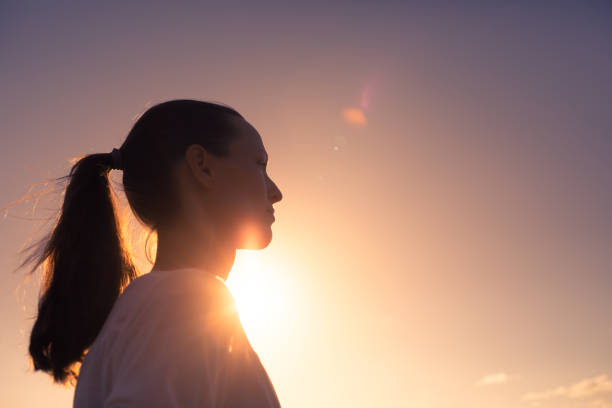 Woman looking far away at sunset.