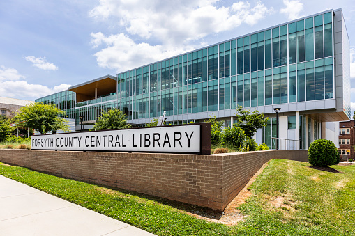 Winston-Salem, NC, USA-1 June 2021: Front diagonal perspective view of Forsyth county Central Library and sign.  Sunny, spring day.  No people.