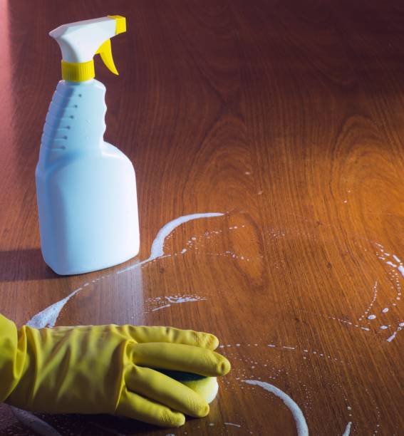 istock A person cleaning a wooden surface using a sprayer, soap and a sponge 1321555670