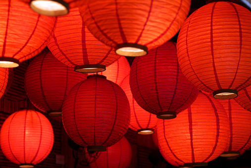 Lit red Japanese lanterns decorating a Sushi bar.