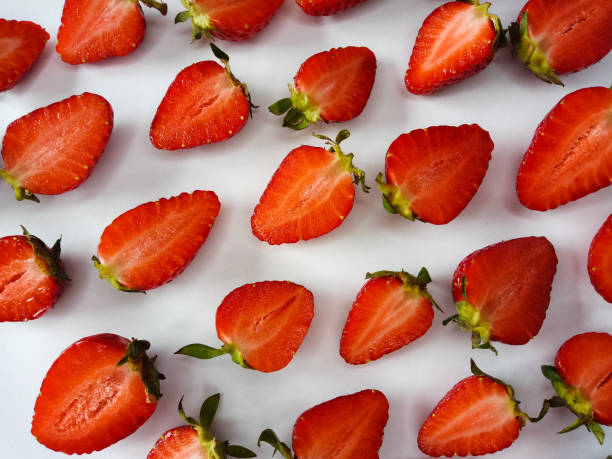 istock strawberries cut in half on a white background 1321560576