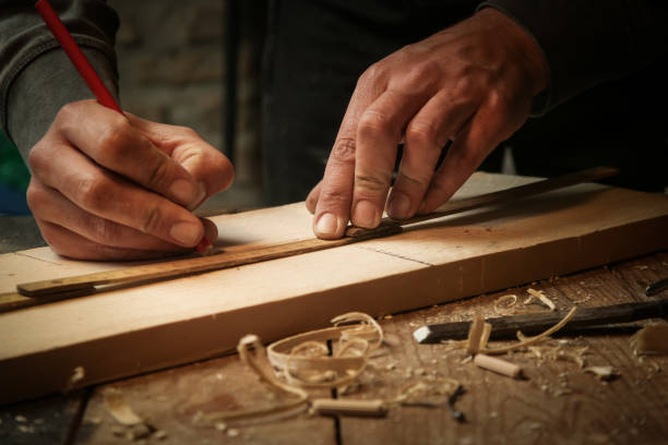 istock Carpenter measuring and marking wood in workshop 1321562693