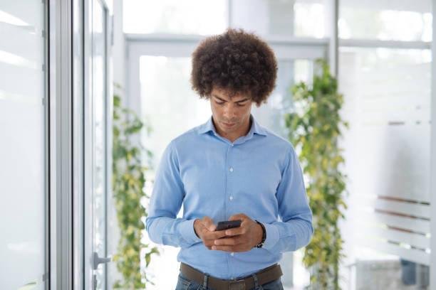 istock Mixed race African American businessman using smart phone in office 1321564389
