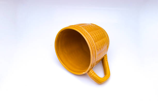 Empty yellow-brown cup with woven bamboo motif isolated on white background