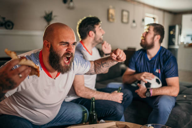 istock Friends watching sport on tv 1321574391