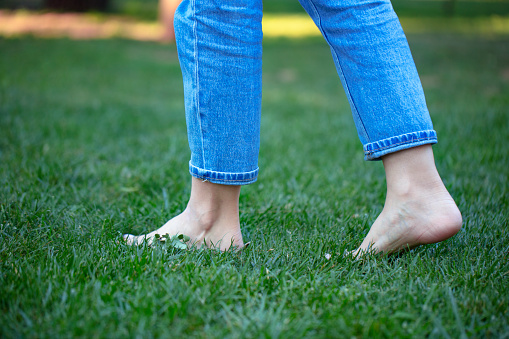 girl walking on the grass, only feet