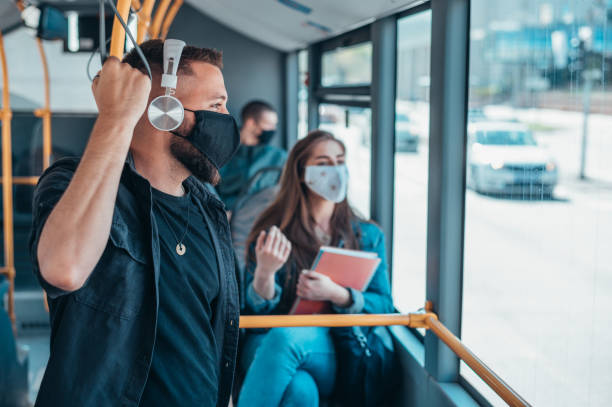 istock Young man wearing protective mask while riding a bus 1321580760