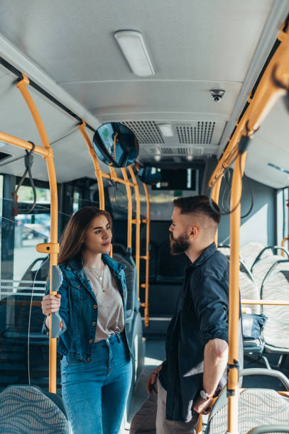 istock Young couple standing in a moving bus while talking 1321580761