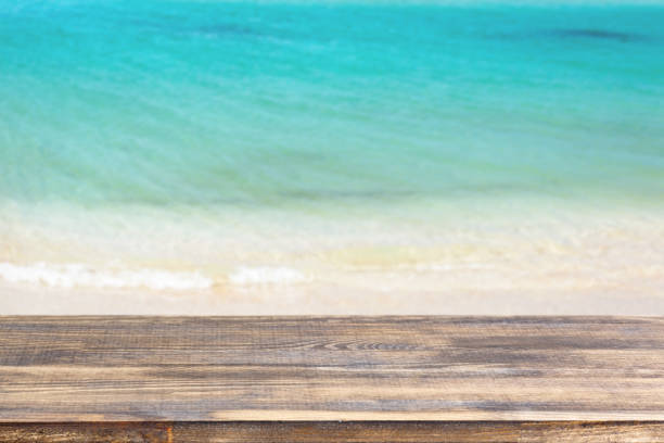 istock wood table top on blur sea background 1321582434