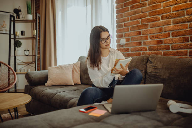 istock A young female student sitting on thek couch using laptop headphones when studying 1321583706