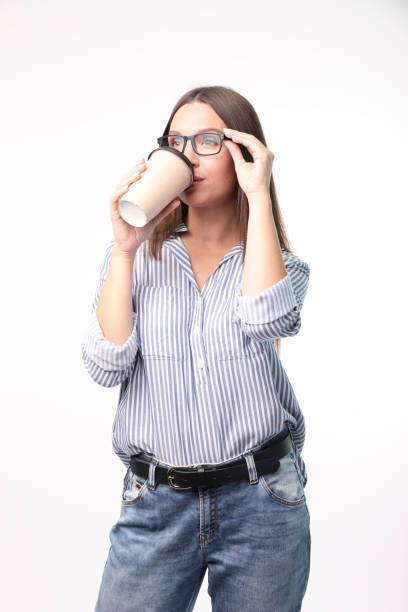 istock Beautiful young woman drinking coffee isolated on white background 1321598073