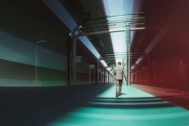 istock Businessman walking in glass corridor 1321598102