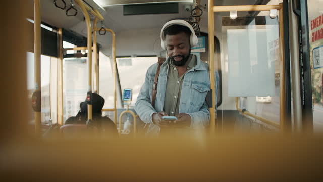 4k video footage of a young man using a smartphone and headphones while traveling on a bus