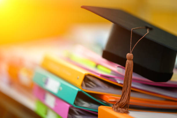 istock A black graduation cap is placed on a file folder on a desk at the office. 1321600379
