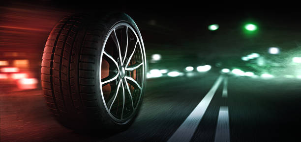 istock Car tires on illuminated street 1321608781