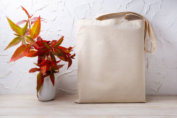 Rustic tote bag mockup with red grass in the vase Canvas tote bag mockup with red fall grass in the white vase. Rustic linen shopper bag mock up for branding presentation tote bag mock up stock pictures, royalty-free photos & images