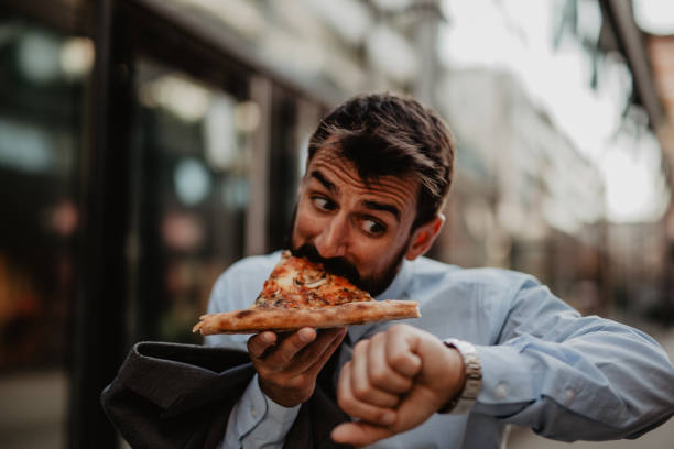istock Grabbing a bite of pizza for the breakfast, before work 1321619516