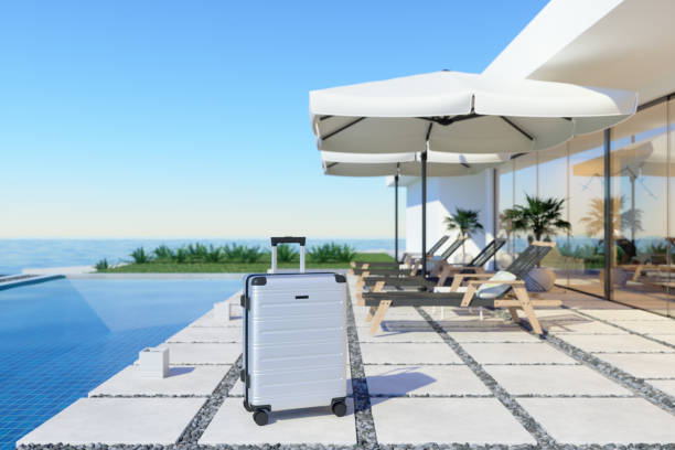 luxury holiday villa exterior with lounge chairs and suitcase near the swimming pool. holiday concept. - swimming pool luxury mansion holiday villa imagens e fotografias de stock
