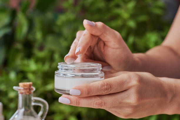 Close up of woman hands holding jar of moisturizing cream. stock photo