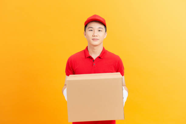 istock Smiling delivery man carrying a parcel box 1321625148
